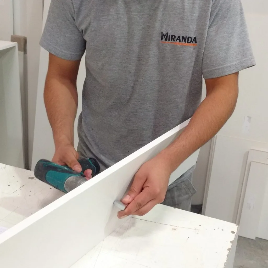 Marceneiro montando um móvel planejado em uma marcenaria para móveis planejados